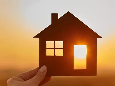 image of a person holding a model of a house