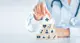 A person with a stethoscope builds a block tower with medical icons