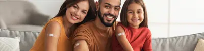 Smiling family with Bandaids on their arms