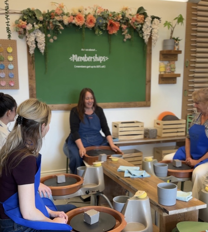 Deanna teaching a clay wheel class.
