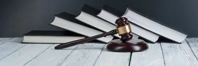 Gavel and books in front of a navy background.