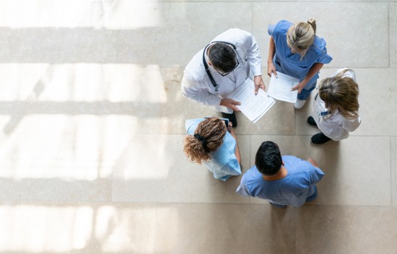 Healthcare staff reviewing papers together in a hallway
