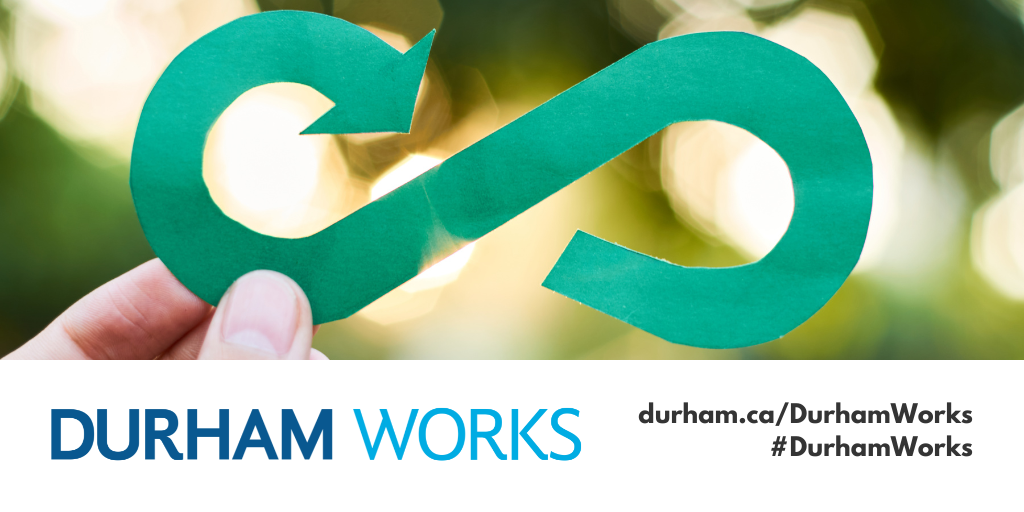 A picture of a person holding a green paper infinity symbol representing the circular economy with a banner underneath with the Durham Works logo and text reading durham.ca/DurhamWorks #DurhamWorks