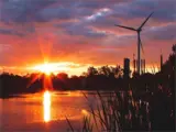 A waterfront at sunset featuring a turbine.