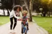 Mother teaching a child to ride a bike. 