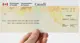 A hand holding a Government of Canada benefits cheque